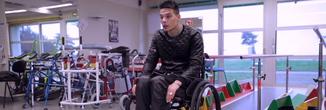 Photo d’une jeune homme dans un fauteuil roulant dans une salle de rééducation.