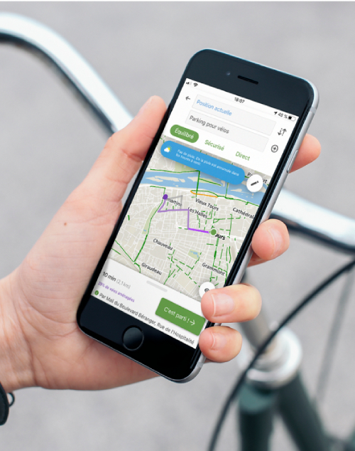 Photo d'une main tenant un smartphone avec une application de type GPS lancé